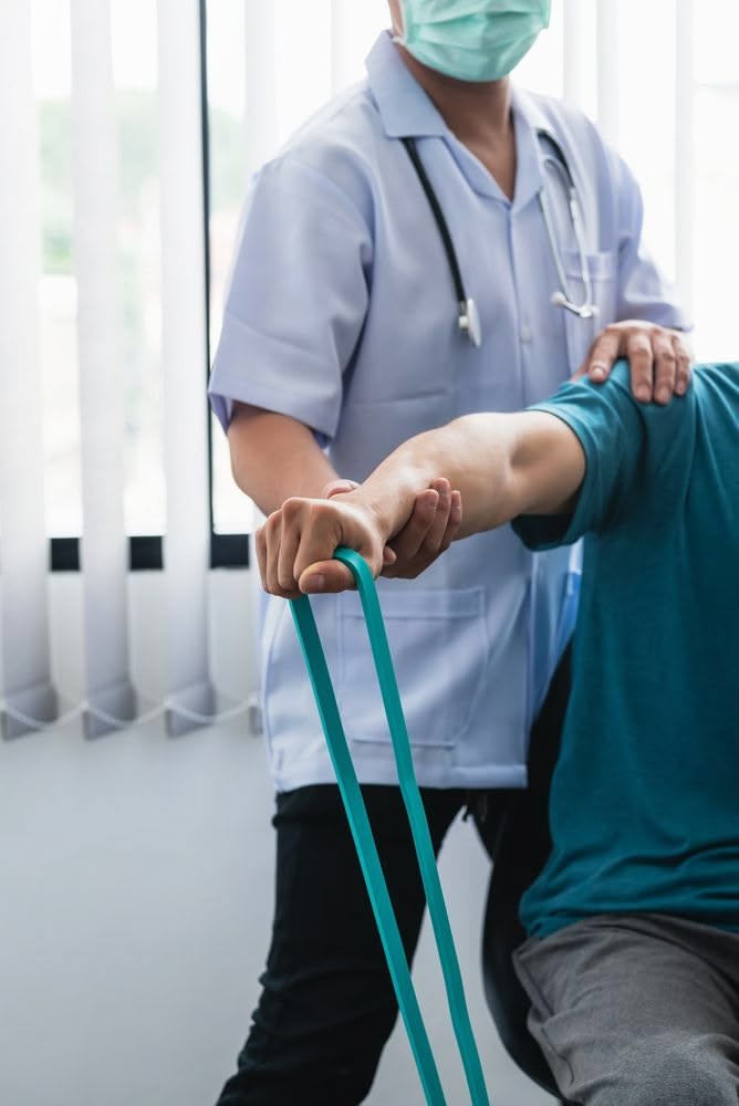 Physiotherapist guiding a patient through a resistance band exercise